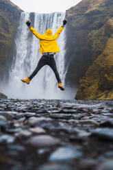 Man jumping near waterfall - ADSF06387