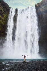 Mann steht in der Nähe eines Wasserfalls - ADSF06390
