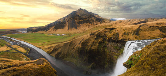 Luftaufnahme einer herrlichen Landschaft mit Bergen und Wasserfall unter bewölktem Himmel, Island. - ADSF06391