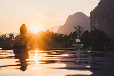 Frau im Pool mit Blick auf die Berge - ADSF06445