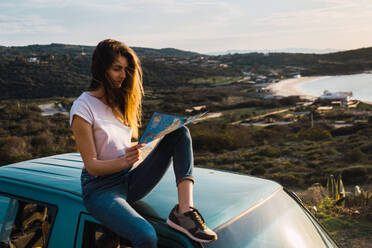 Woman with map on car roof - ADSF06506