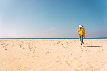 Woman standing on sandy shore - ADSF06517