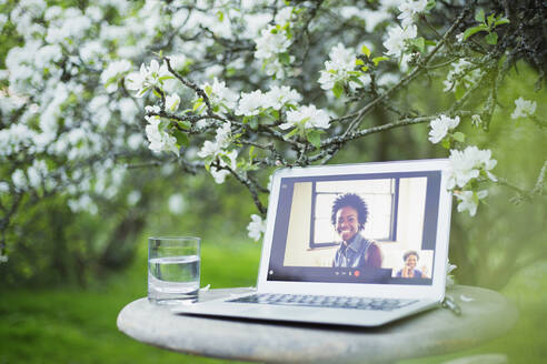 Videochat von Kollegen auf dem Laptop-Bildschirm im Garten - CAIF28913