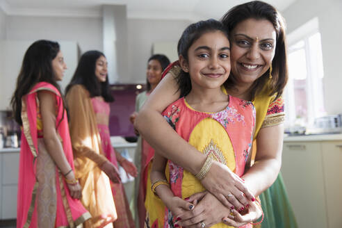 Portrait happy Indian mother and daughter in saris hugging - CAIF28992