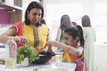 Indische Mutter und Tochter in Saris kochen Essen in der Küche - CAIF29029