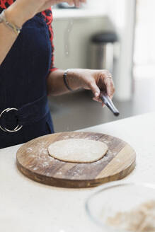 Frau macht Naan-Brot in der Küche - CAIF29044