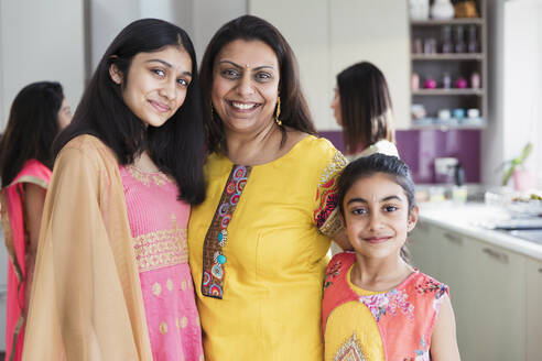 Portrait happy Indian mother and daughters in saris - CAIF29048