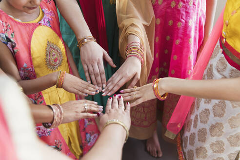 Indian women in saris joining hands in circle - CAIF29061