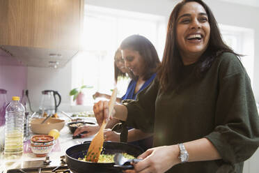 Glückliche indische Frauen kochen Essen in der Küche - CAIF29064