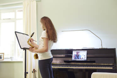 Mädchen nimmt Online-Saxophonunterricht zu Hause - CAIF29110