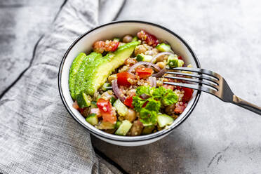 Bowl of vegetarian quinoa salad with chick-peas, avocado, cucumber, tomato, onion and parsley - SARF04606