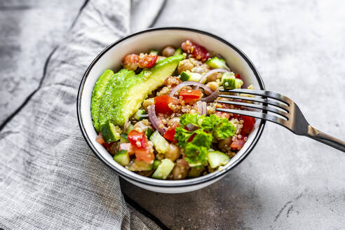 Schüssel mit vegetarischem Quinoa-Salat mit Kichererbsen, Avocado, Gurke, Tomate, Zwiebel und Petersilie - SARF04606