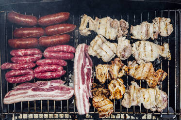 Close-up of meat cooking on barbecue grill in yard - JCMF01057