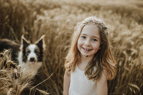 Nettes lächelndes Mädchen mit Border Collie Hund im Weizenfeld - GMLF00342