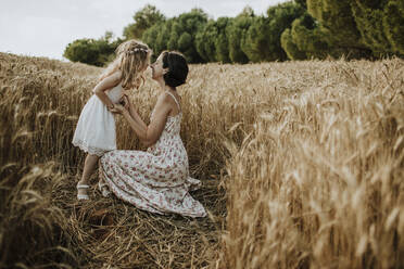 Mother and daughter spending leisure time in wheat field - GMLF00343