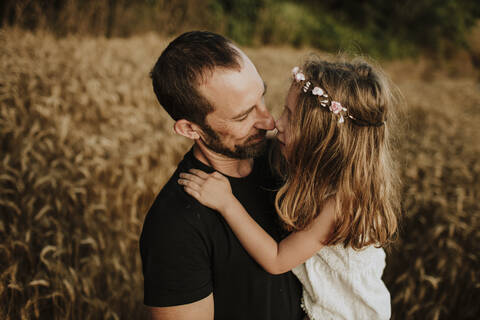 Father and daughter making wonderful memories together in wheat farm stock photo