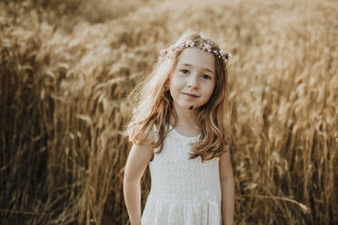 Cute blond girl standing in field of wheat - GMLF00349