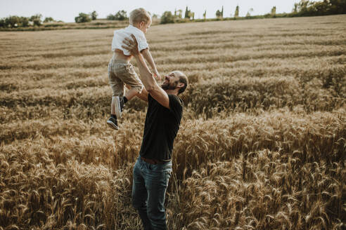 Vater verbringt seine Freizeit mit seinem Sohn auf einem Weizenfeld - GMLF00350