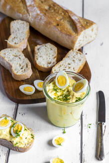 Aufgeschnittenes Baguette und ein Glas hausgemachter Eiersalat mit Kresse - SARF04610