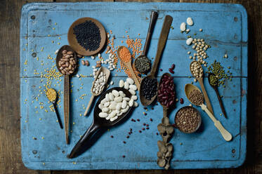 Various beans and lentils on blue rustic wooden surface - ASF06640