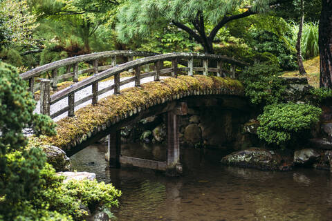 Japan, Kyoto, Footbridge over pond in Japanese garden stock photo