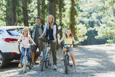 Smiling family with bicycles in woods - CAIF29125