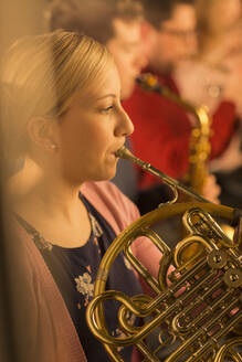 Frau spielt Waldhorn im Orchester - CAIF29196