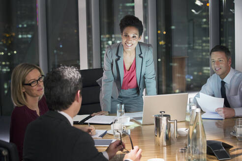 Business people meeting in conference room at night - CAIF29256