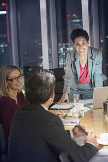 Business people meeting in conference room at night - CAIF29276