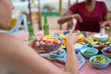 Junge Frau beim Mittagessen am Terrassentisch - CAIF29362