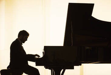 Silhouette eines Pianisten beim Spielen - CAIF29406
