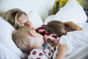 Mother with sons sleeping in bed - CAIF29452