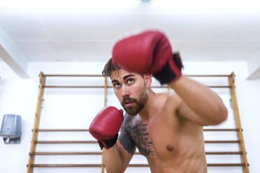 Junger Mann beim Boxtraining in einem Fitnessstudio - ADSF06765