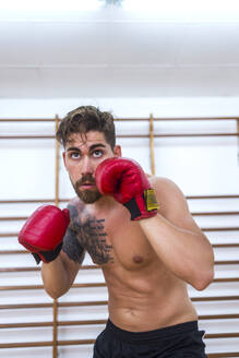 Junger Mann beim Boxtraining in einem Fitnessstudio - ADSF06766