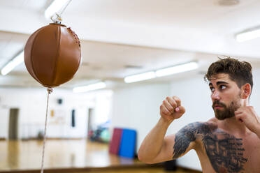 Junger Mann beim Boxtraining in einem Fitnessstudio - ADSF06767