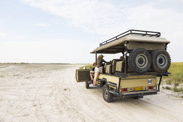 Thirteen year old leaning on safari vehicle, Botswana - MINF14929