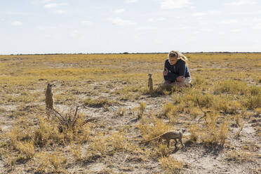 12-jähriges Mädchen beobachtet Erdmännchen in der Kalahari-Wüste - MINF14966