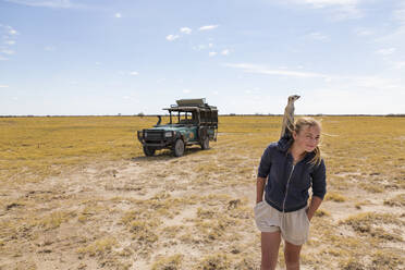 12-jähriges Mädchen mit Erdmännchen auf dem Kopf, Kalahari-Wüste - MINF14968
