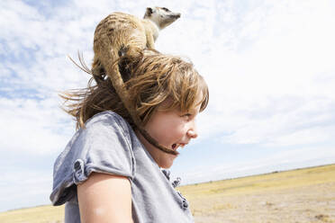 5 Jahre alter Junge mit Erdmännchen auf dem Kopf, Kalahari-Wüste, Makgadikgadi-Salzpfannen, Botswana - MINF14987