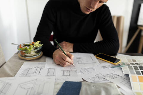 Male architect working on sketch at home office stock photo