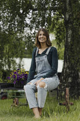 Porträt einer lächelnden jungen Frau mit Blumenkasten - GUSF04213