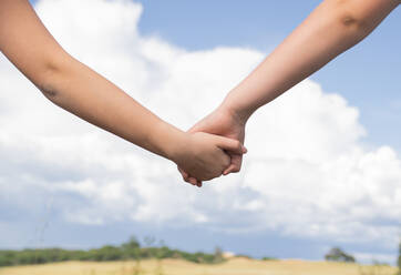 Helping hand between two brothers in the background of the blue sky, Family - CAVF87487