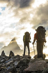 Rear view of two mountaineers hiking towards Mt. Loki, Baffin Island. - CAVF87634