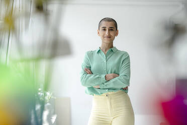 Portrait of a confident woman standing in loft office - KNSF08215