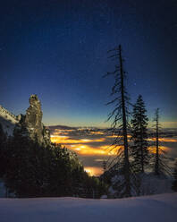 Illuminated valley seen from snowcapped mountain peak at night - MALF00032