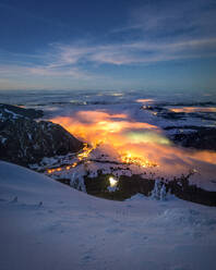 Distant lights seen from snowcapped peak at night - MALF00040