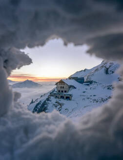 Abgeschiedene Berghütte durch ein Loch im Schnee gesehen - MALF00046