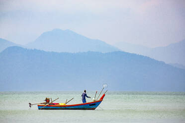 Fischer auf kleinem Boot, Straße von Malakka mit der thailändischen Insel Ko Tarutao vom Datai Bay Beach (Pantai Teluk Datai), Andamanisches Meer, Malaysia, Südostasien, Asien - RHPLF16283