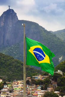 Brasilianische Flagge mit einer Favela und der Christusstatue auf dem Corcovado-Gipfel im Hintergrund, Rio de Janeiro, Brasilien, Südamerika - RHPLF16359