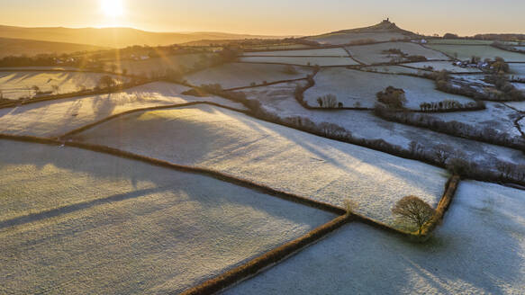 Drohnenansicht des frostigen Wintersonnenaufgangs über dem Dartmoor bei Brentor, Devon, England, Vereinigtes Königreich, Europa - RHPLF16501